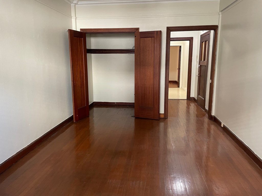 an empty room with wooden floors and doors